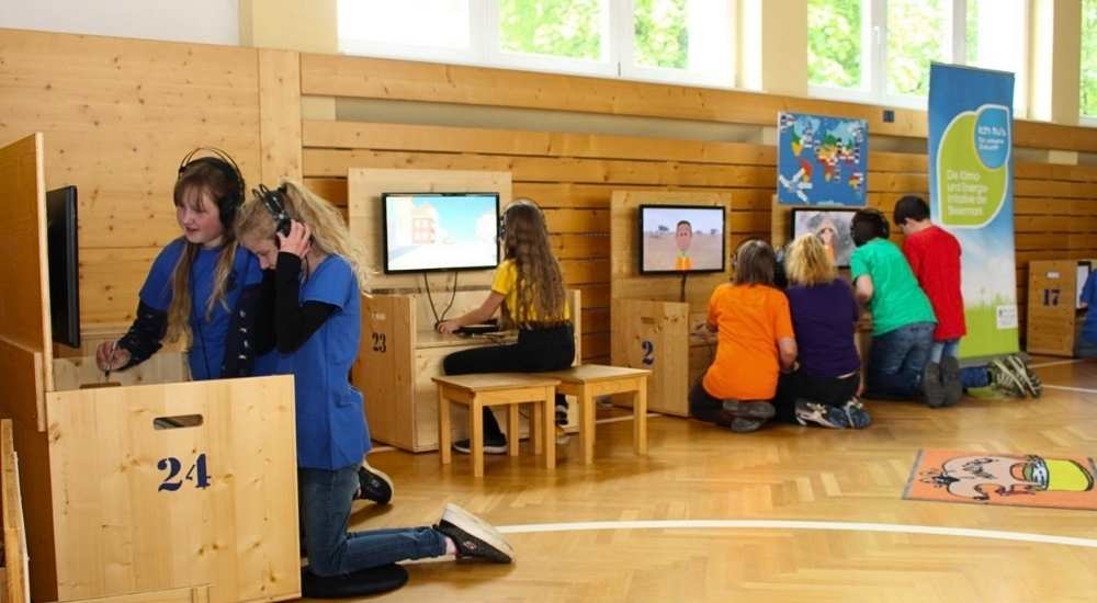 Klimaversum Wanderausstellung - Kinder spielen an interaktiven Stationen