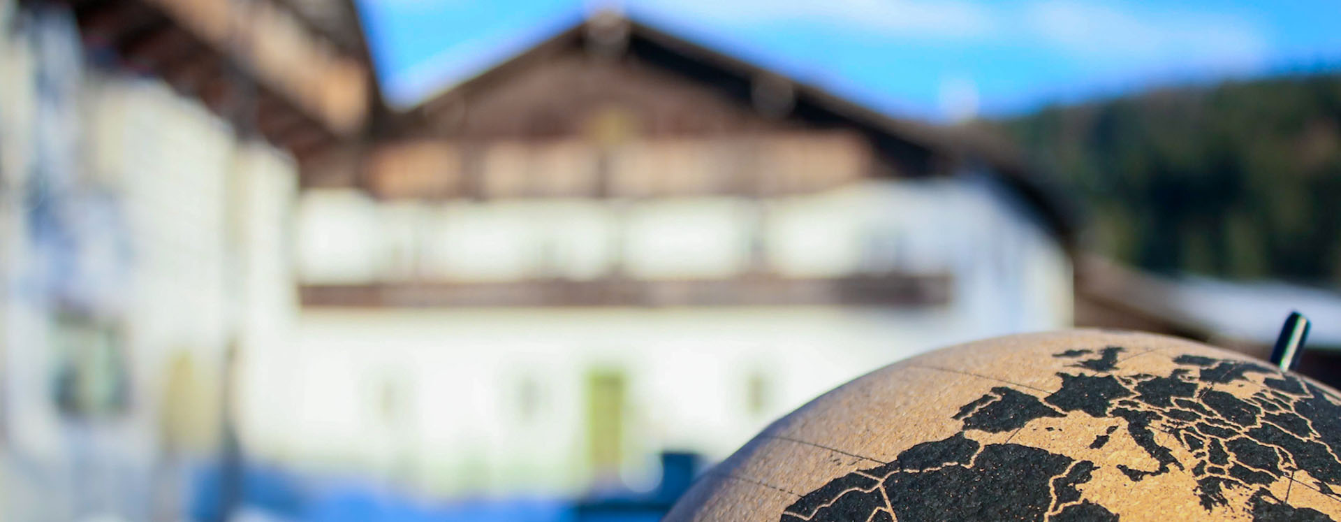 Globus vor einem Tiroler Bauernhaus, Klimabündnis-Gemeinden Tirol
