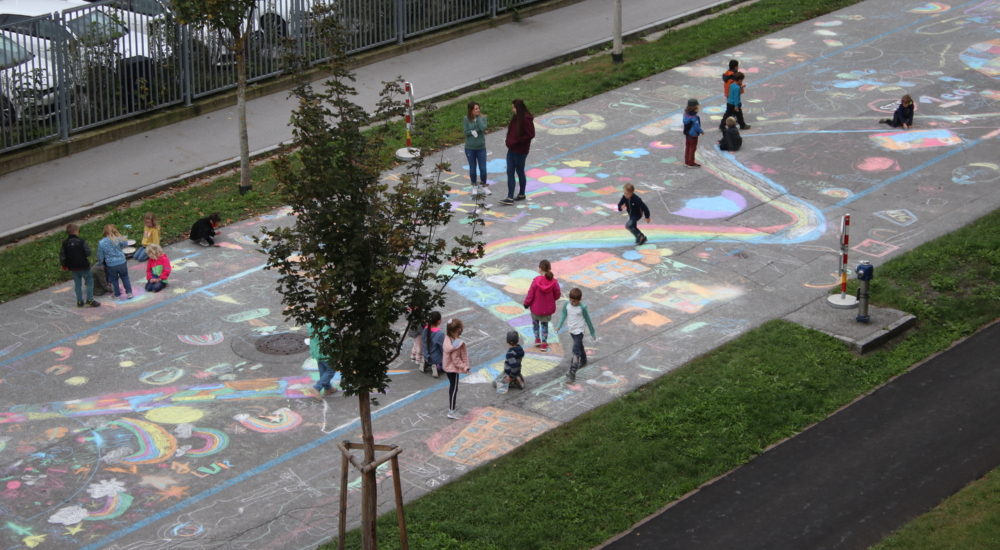 Kinder malen mit Kreide auf Straße Ansicht von oben