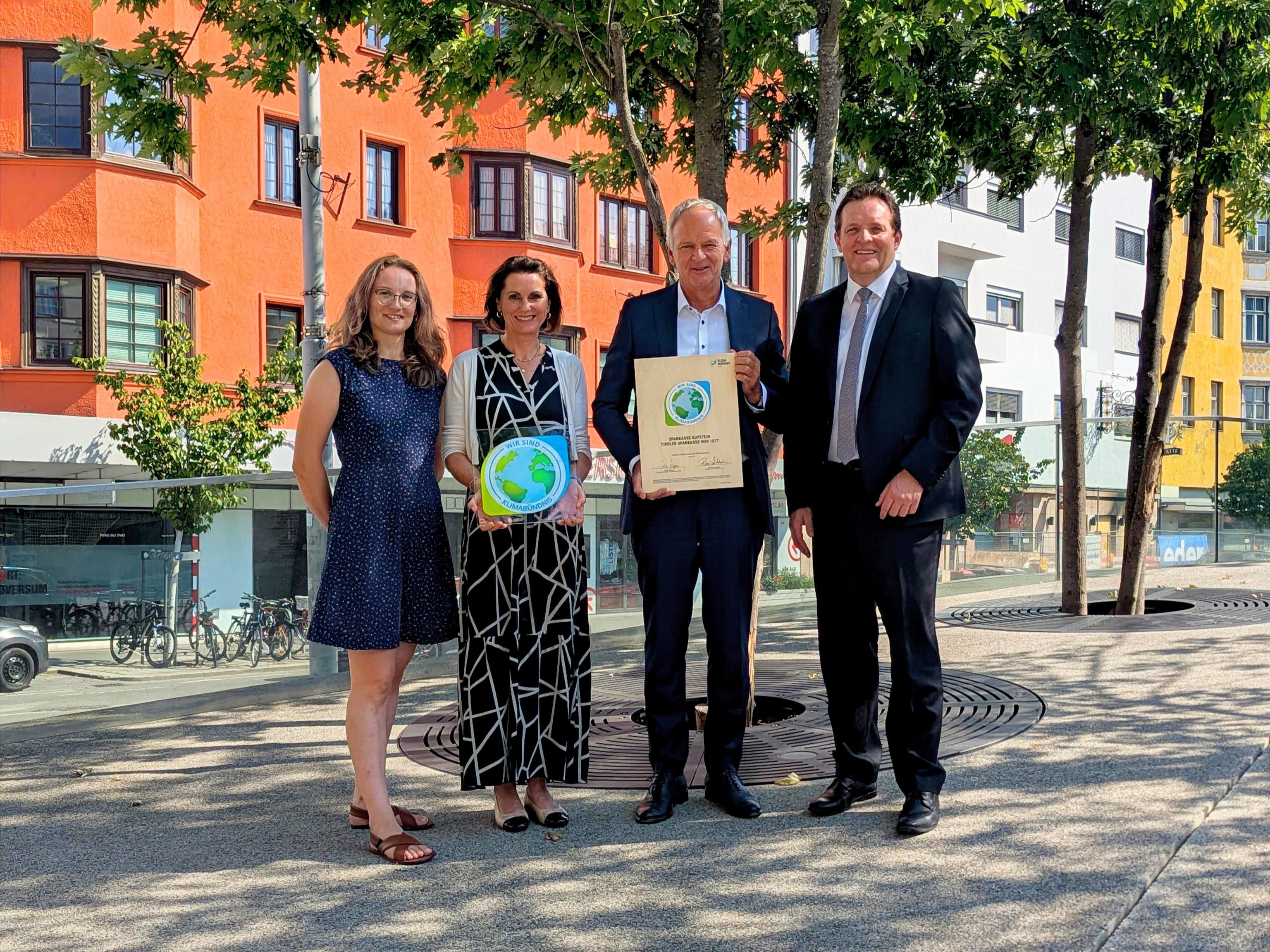 Johanna Nagiller, Mitarbeiterin des Klimabündnis und Klimabündnis-Obmann René Zumtobel überreichen der Nachhaltigkeitsbeauftragte Daniela Schwaiger und Vorstandsvorsitzender Klaus Felderer die Urkunde