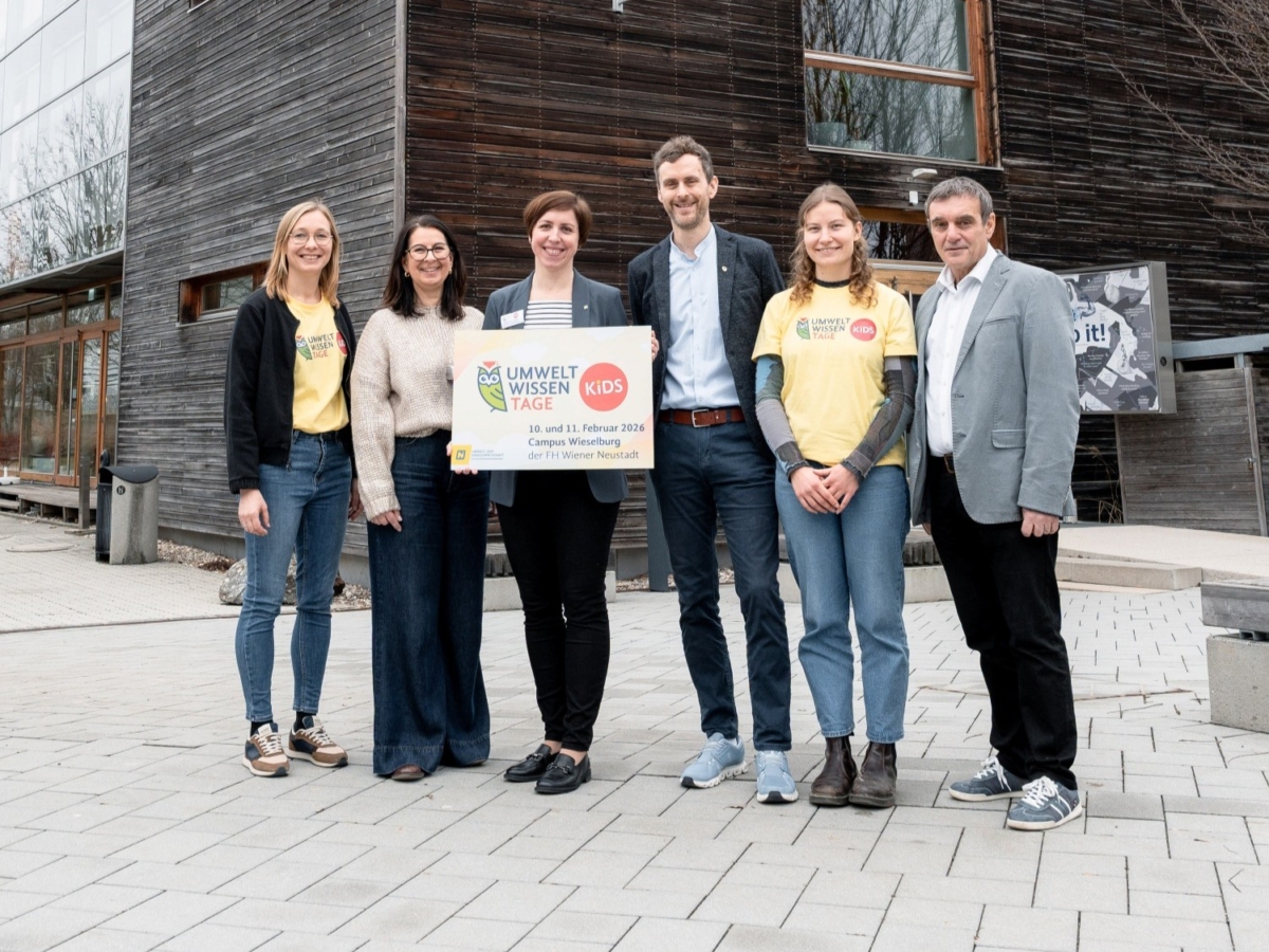 Gruppenbild von sechs Erwachsenen, die einen Schild der Umwelt Wissen Tage halten
