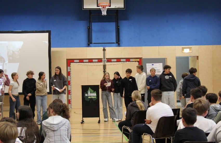 Kinder sprechen im Turnsaal vor Publikum